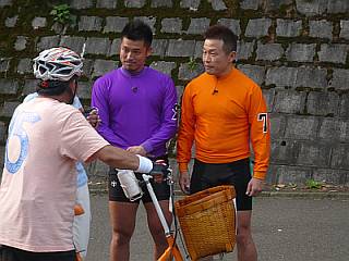 大塚さんに自転車の乗り方をレクチャーしている白戸淳太郎
            選手（S1）と東山公昭選手（A1）。